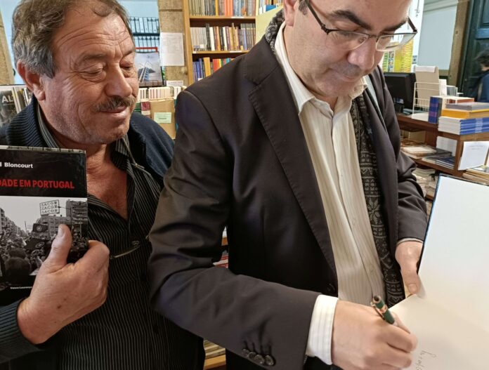 Daniel Bastos autografando o livro “Gérald Bloncourt – Dias de Liberdade em Portugal” durante encontro em homenagem ao fotojornalista na livraria Unicepe. Foto divulgação