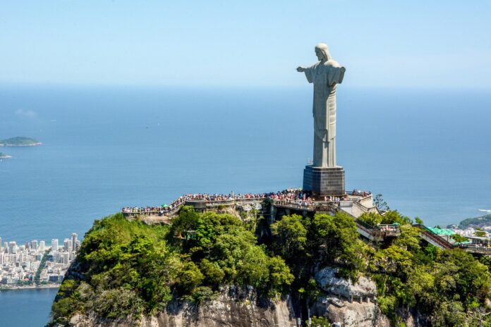 Dois paraquedistas escalam a estátua do Cristo Redentor antes de saltar em direção à Lagoa Rodrigo de Freitas, na manhã desta quarta-feira (10). Foto Jose Guertzenstein