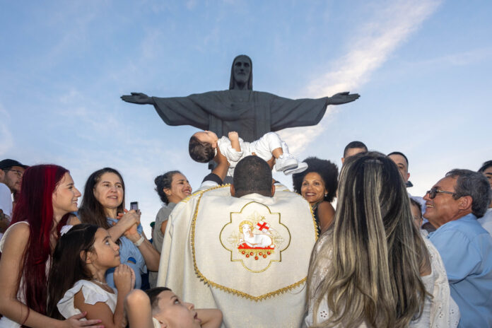 Adultos e crianças recebem o sacramento do Batismo aos pés do Cristo Redentor, no Rio de Janeiro. Foto Guilherme SilvaSantuário Cristo Redentor